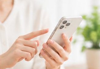 スマートフォンを操作する手元